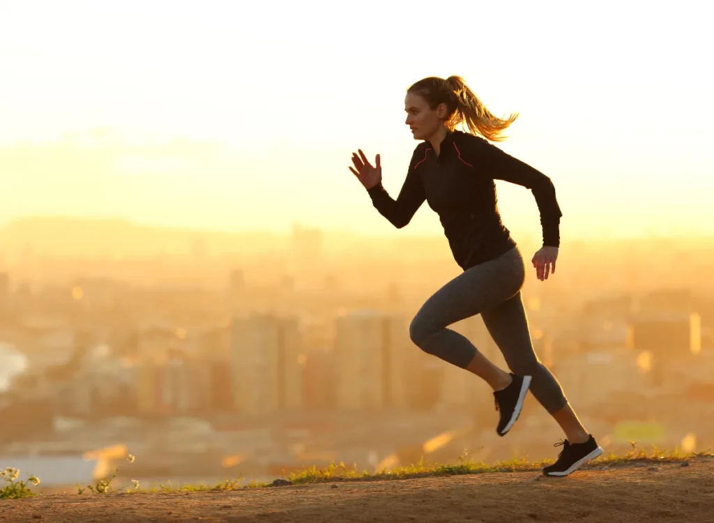 Woman running during the sunset. This is a side view of her.